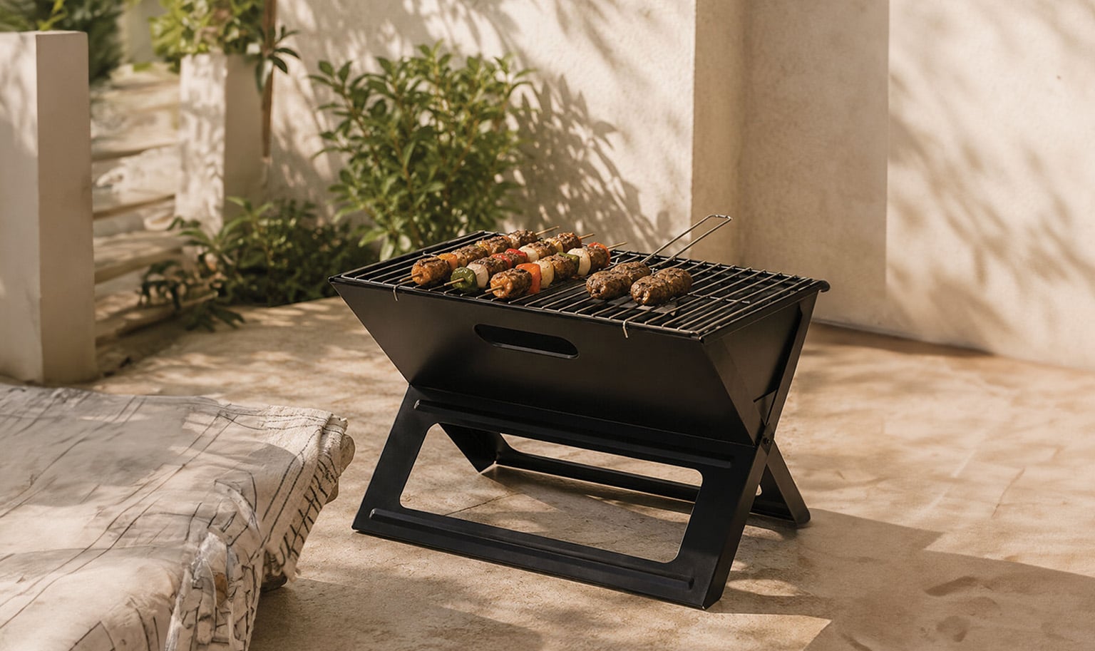 Compact outdoor pizza oven with chimney placed on a table, ideal for garden and patio cooking
